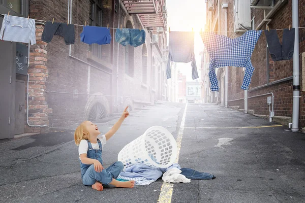 Glückliches kleines Mädchen mit gewaschenen Kleidern — Stockfoto
