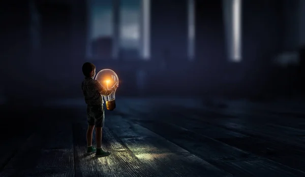 Boy holding a light bulb — Stock Photo, Image