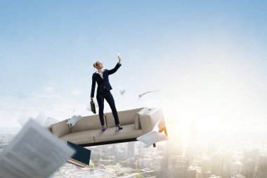 İş kadını manzaraya karşı duruyor ve selfie çekiyor.