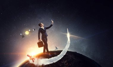 İş kadını uzay manzarasına karşı duruyor ve selfie çekiyor.