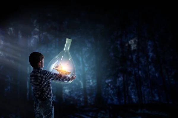 Хлопчик тримає скляну колбу з пейзажем всередині неї — стокове фото