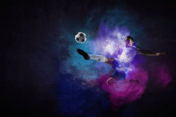 Chłopiec gra w piłkę nożną uderzając piłkę — Zdjęcie stockowe