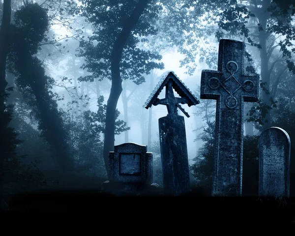 Medieval stone crosses and tombstones, cemetery in misty forest — Stock Photo, Image