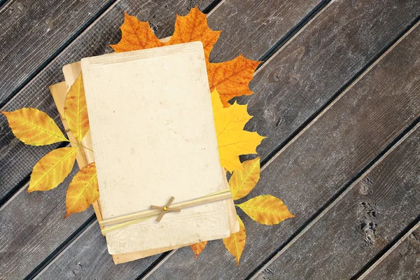 Cartes anciennes et feuilles d'automne sur vieux planches en bois . — Photo