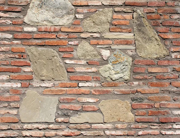 Forntida fästningsvägg med tegel och stenblock — Stockfoto