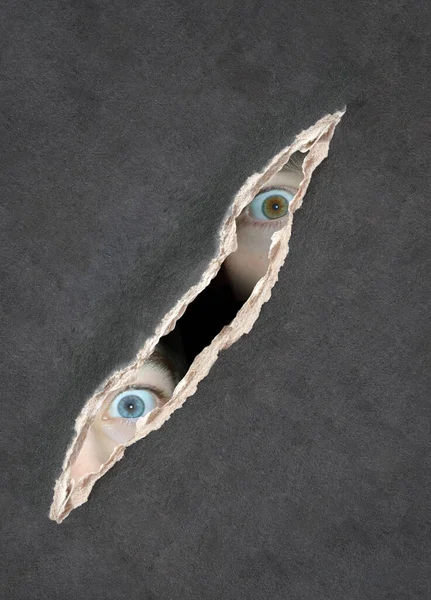 黑暗中的一瞥 两个高加索孩子的眼睛透过纸孔看过去 复制文本的空间 模拟模版 — 图库照片