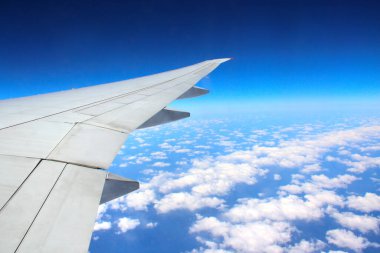 Seyahat konsepti. Bulutların havadan görünüşü. Bir uçağın penceresinden dışarı bakıyorum. Bir uçağın kanatlı manzara