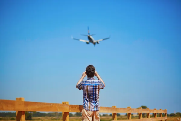 Man is looking at the glide path and landing plane — Stock Photo, Image