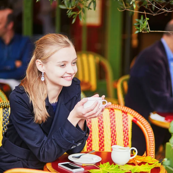 Hermosa joven bebiendo chocolate caliente en la cafetería al aire libre parisina —  Fotos de Stock