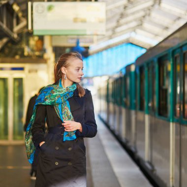 Paris underground platformda bir tren bekleyen genç kadın