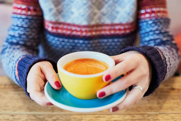 Belle mani di donna con manicure rossa e tazza di caffè caldo fresco sul tavolo di legno — Foto Stock