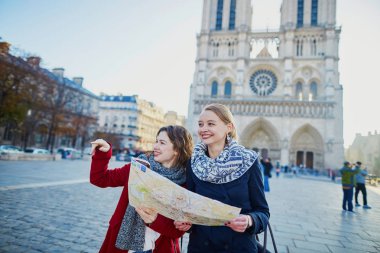 İki genç kız selfie alarak Notre-Dame de Paris yakınındaki