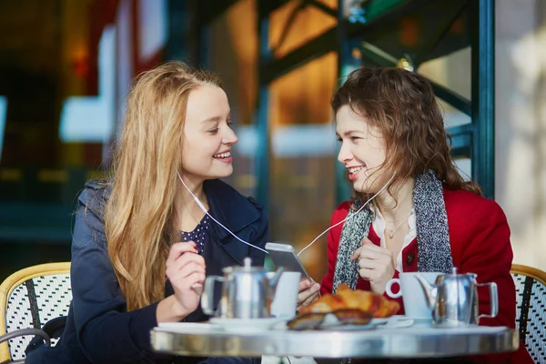 Dos chicas jóvenes en la cafetería al aire libre parisina — Foto de Stock