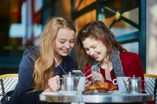 Twee jonge meisjes in de Parijse outdoor cafe — Stockfoto