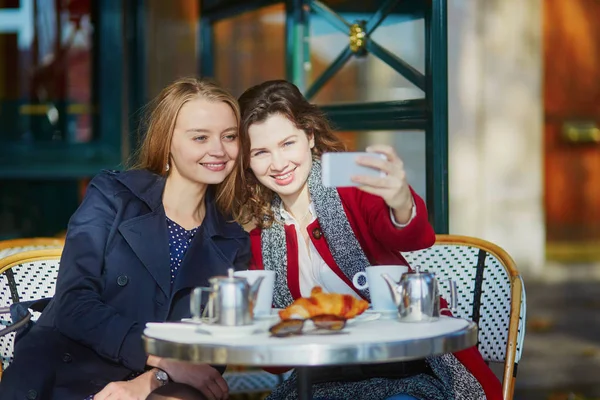 Twee jonge meisjes in de Parijse outdoor cafe — Stockfoto