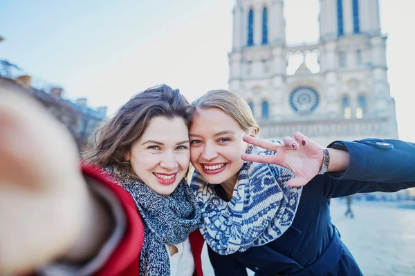 Two young girls taking selfie near Notre-Dame in Paris — Stock Photo, Image