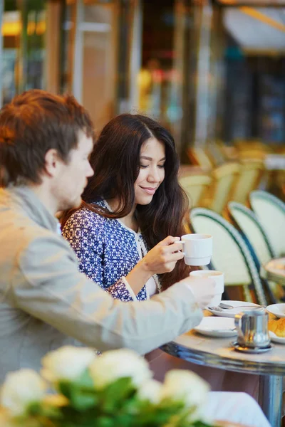 Ζευγάρι πίνει καφέ και τρώει κρουασάν σε παρισινό café — Φωτογραφία Αρχείου