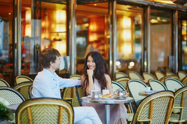 Paar trinkt Kaffee und isst Croissants in Pariser Café — Stockfoto
