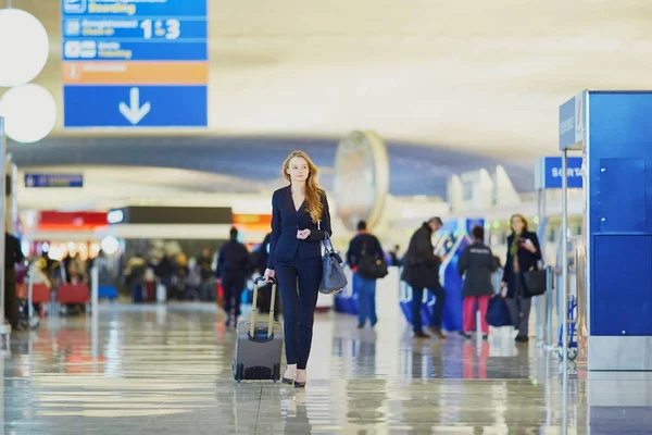 Affärskvinna med handbagage i internationella flygplats — Stockfoto