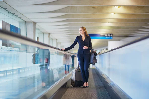 Business woman with hand luggage in international airport — Stock Photo, Image