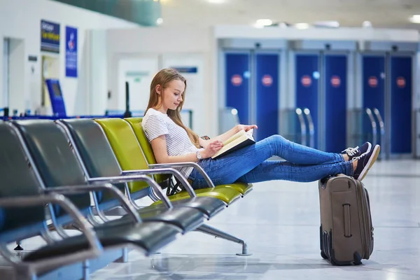 Όμορφα τουριστικά νεαρό κορίτσι με σακίδιο και μεταφορά των αποσκευών στο Διεθνές Αεροδρόμιο — Φωτογραφία Αρχείου