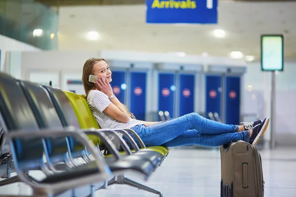 Hermosa joven turista con mochila y llevar equipaje en el aeropuerto internacional — Foto de Stock