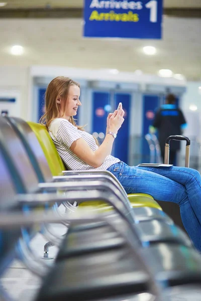 Bela jovem turista com mochila e levar bagagem no aeroporto internacional — Fotografia de Stock