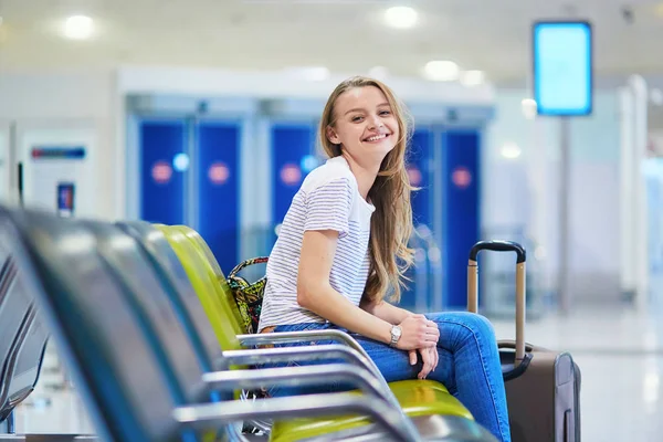 Όμορφα τουριστικά νεαρό κορίτσι με σακίδιο και μεταφορά των αποσκευών στο Διεθνές Αεροδρόμιο — Φωτογραφία Αρχείου