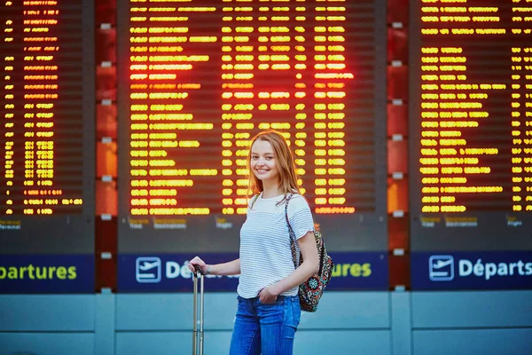 Mooie jonge toeristische meisje met rugzak en draagtasje van bagage in de internationale luchthaven — Stockfoto