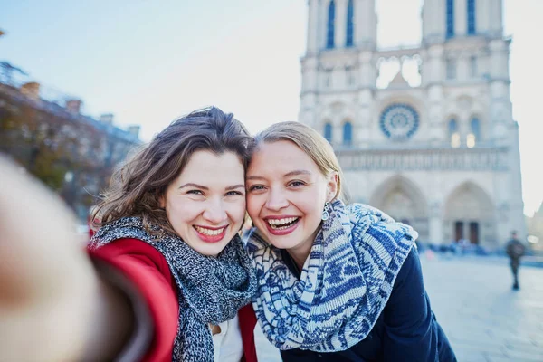 Two young girls taking selfie near Notre-Dame in Paris — Stock Photo, Image