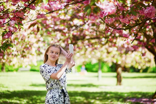 Beautiful young woman in blooming spring park — Stock Photo, Image