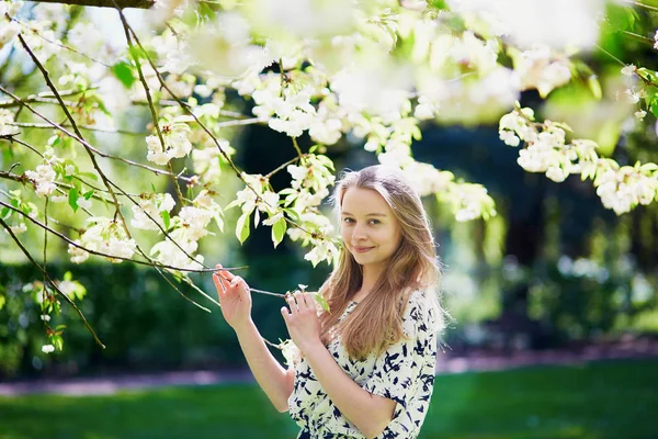 Smuk ung kvinde i blomstrende forårspark - Stock-foto
