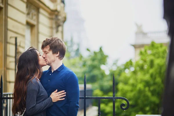 Happy young couple in front of the Eiffel tower — Stock Photo, Image