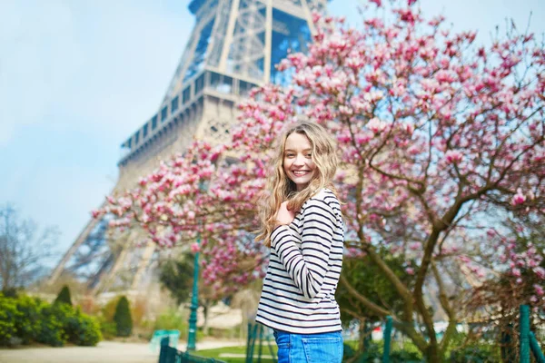 Girl in Paris near the Eiffel tower and pink magnolia — Stock Photo, Image