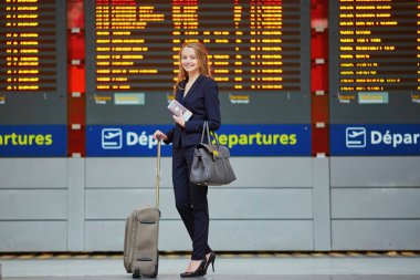 Bilgi tahtaya bakıyor kadınla el bagajı Uluslararası Havaalanı terminal,