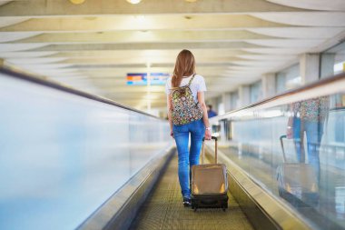 Sırt çantası ve travelator üzerinde Uluslararası Havaalanı Bagaj devam ile turist kız