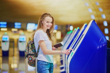 Self check-in yaparken turist kızla sırt çantası ve Uluslararası Havaalanı, Bagaj devam