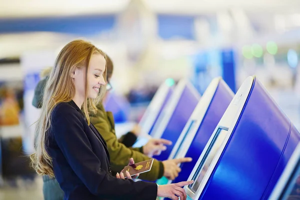 Jovem mulher de negócios fazendo check-in automático no terminal do aeroporto internacional — Fotografia de Stock