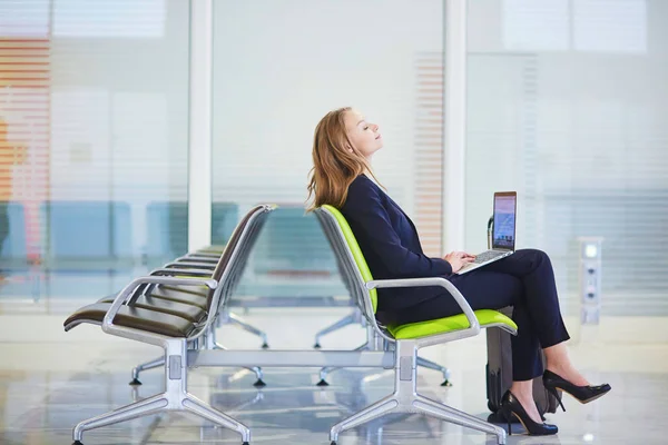 Frau im internationalen Flughafen-Terminal, arbeitet an ihrem Laptop — Stockfoto