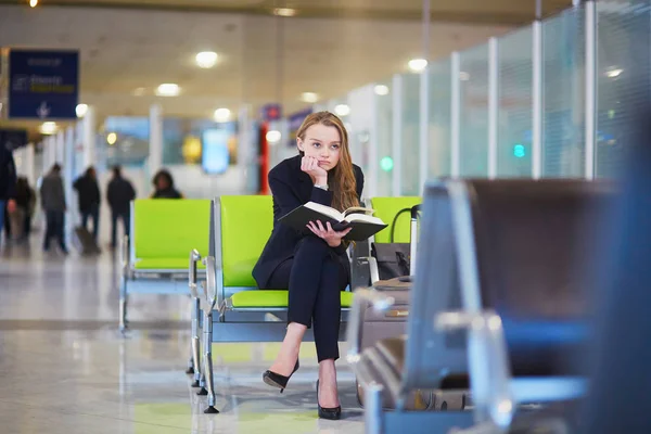 Mulher no terminal do aeroporto internacional, livro de leitura — Fotografia de Stock