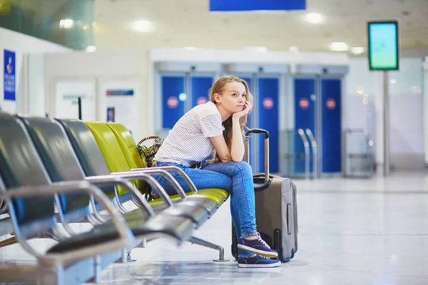 Menina turística no aeroporto internacional, à espera de seu voo, olhando chateado — Fotografia de Stock