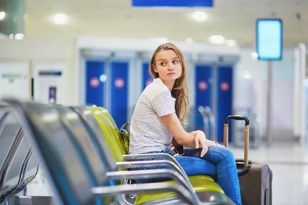 Turisztikai lány nemzetközi repülőtér várja őt a repülés látszó ideges — Stock Fotó