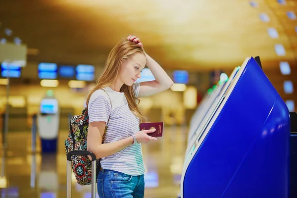 Elégedetlen turista lány nemzetközi repülőtéren, csinál a saját check-in — Stock Fotó