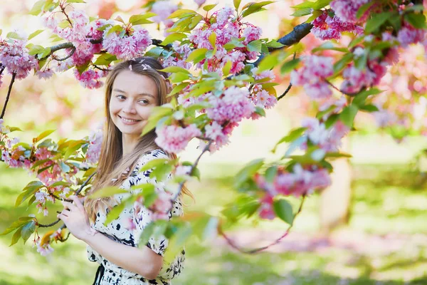 Beautiful young woman in blooming spring park — Stock Photo, Image