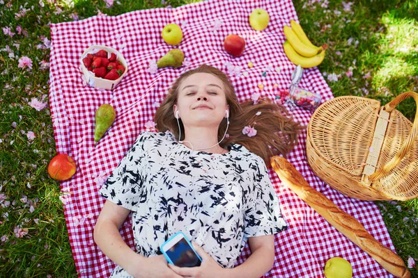 Beautiful young woman having picnic in park — Stock Photo, Image