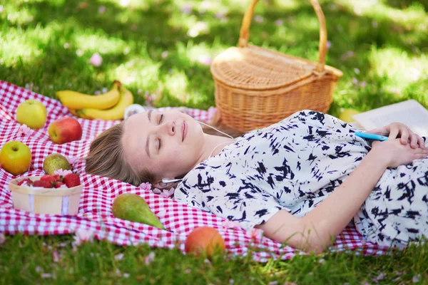 Krásná mladá žena s piknik v parku — Stock fotografie