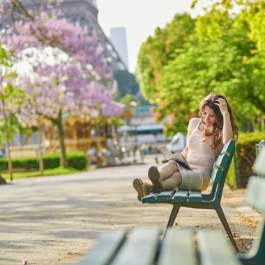 Kadın Paris, Eyfel Kulesi yakınındaki bir kitap okuma