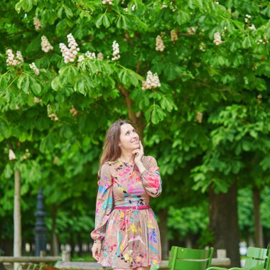 Tam Bloom kestane ağaçları altında yürüyen genç kadın Tuileries bahçesinde