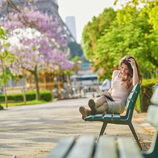 여 자가 파리에서 에펠 탑 근처 책을 읽고 — 스톡 사진