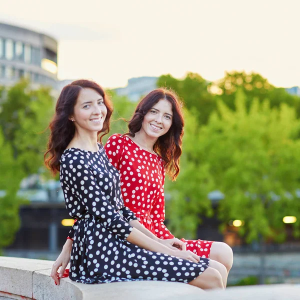 Wunderschöne Zwillingsschwestern in rot und schwarz gepunkteten Kleidern — Stockfoto